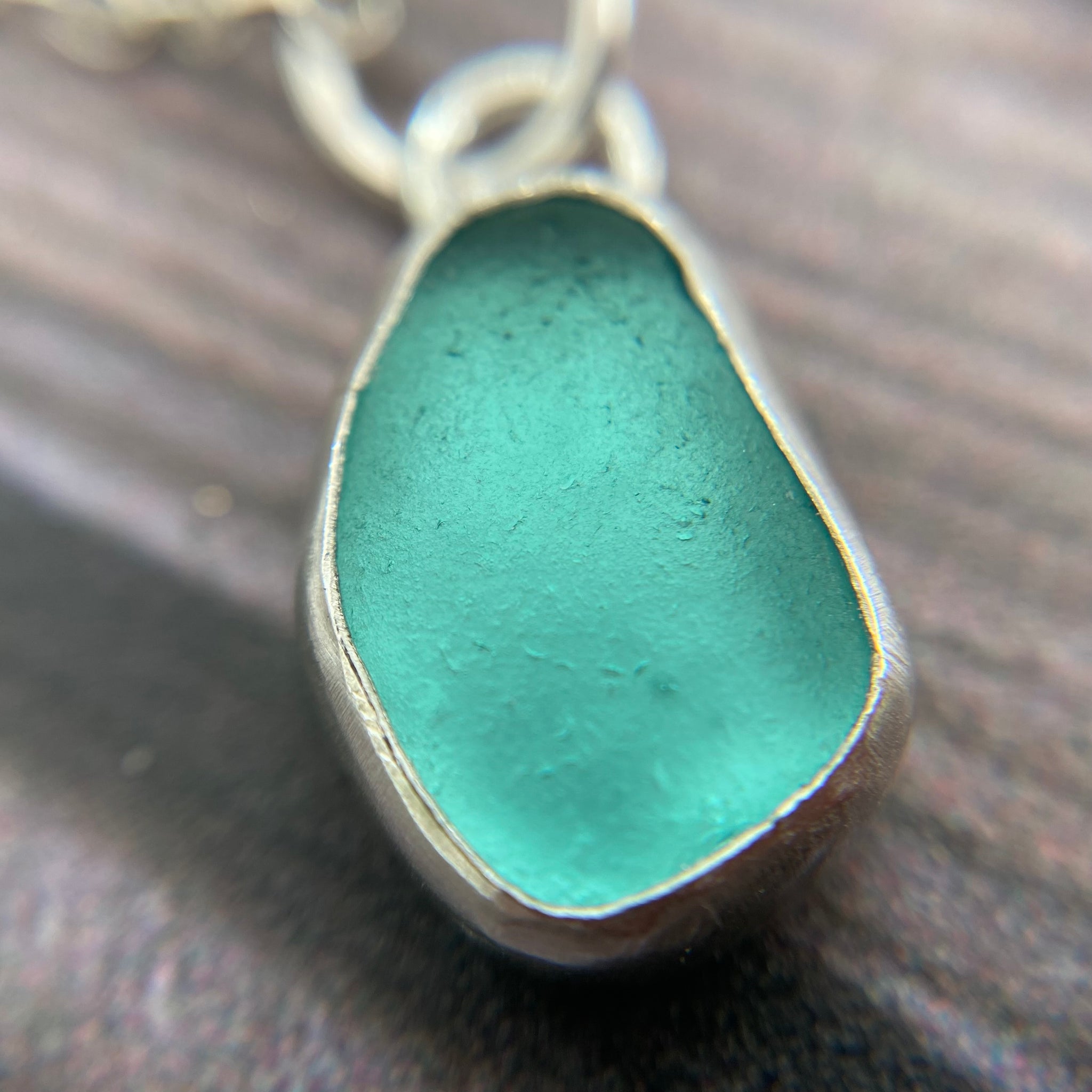 Turquoise Seaham sea glass from the famous seaglass beach, handset shops in recycled fine silver open bezel ,hanging on a diamond cut silver chain